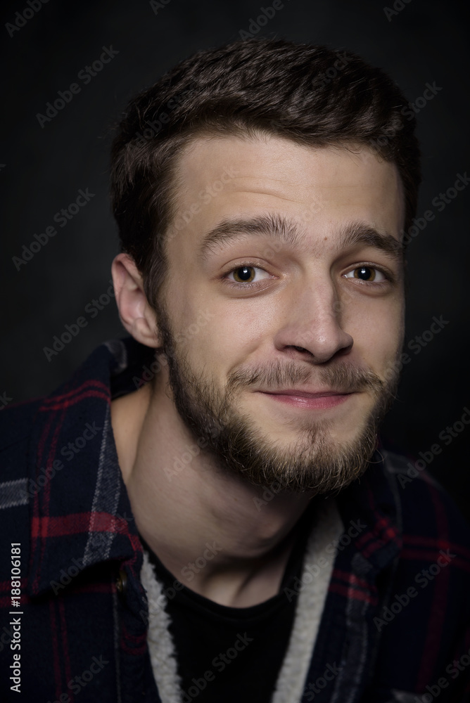 Portrait of a young man with a beard on a dark background. Portrait of a young man with a beard on a dark background.