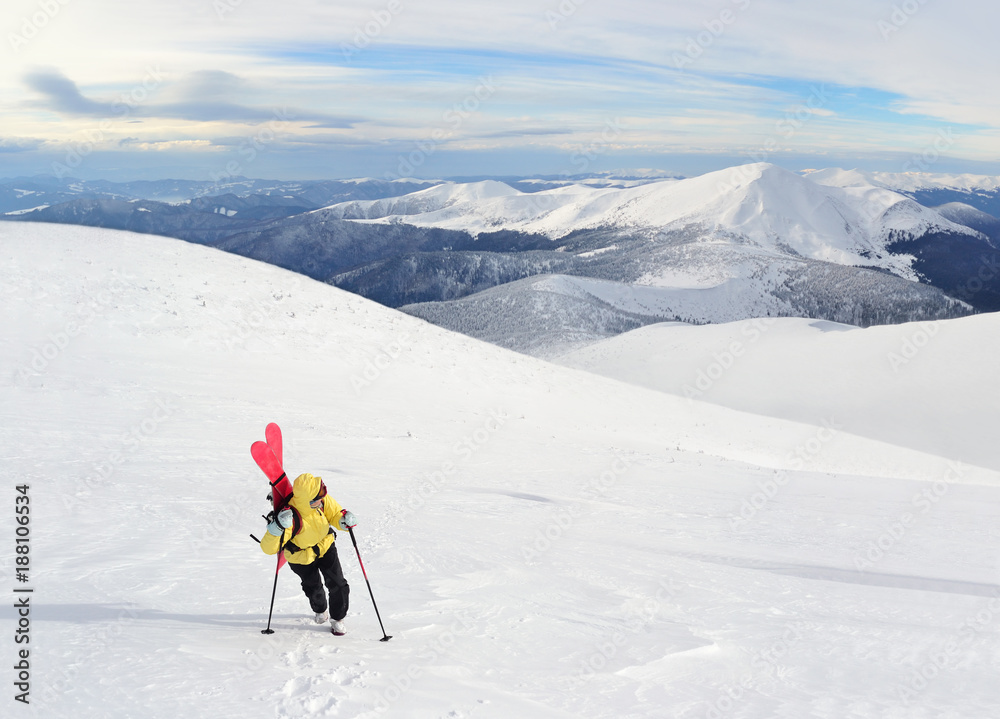 Alpine touring skier hiking in winter mountains.