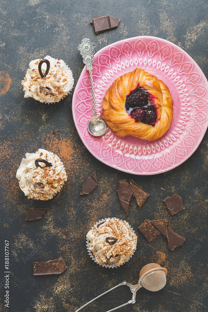 Bun with raspberry jam. Cupcakes with cream and nuts. View from above. Bun with raspberry jam. Cupcakes with cream and nuts. View from above.