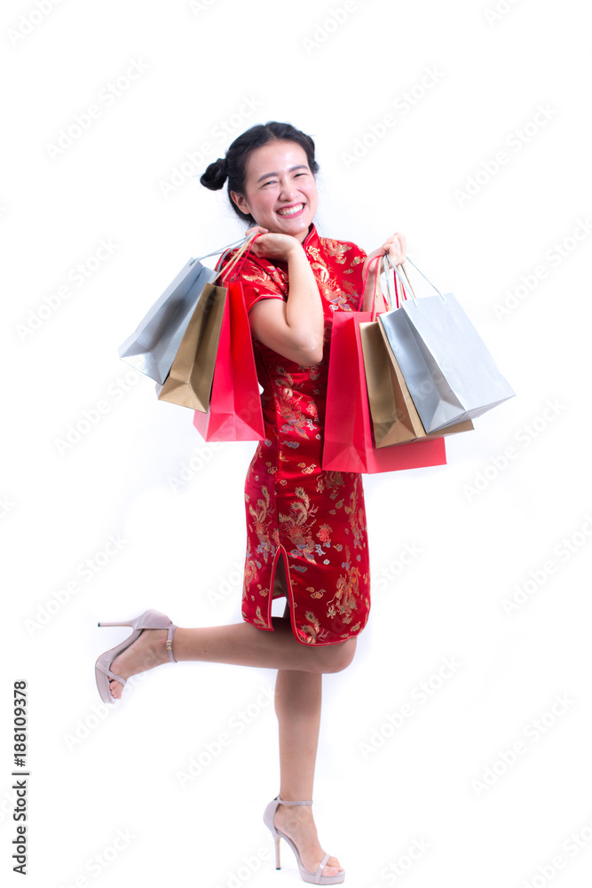 Young asian woman wearing chinese dress traditional cheongsam with Carrying a shopping bag and smile. Chinese New Year Festivities, New Year Celebration, Shopping concept, on white background. Young asian woman wearing chinese dress traditional cheongsam with Carrying a shopping bag and smile. Chinese New Year Festivities, New Year Celebration, Shopping concept, on white background.