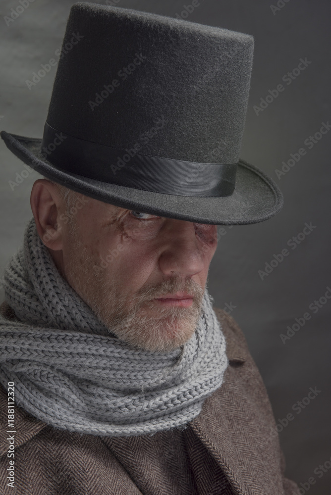Vertical close up portrait of a mature man in period costume outfit with a top hat and grey scarf Vertical close up portrait of a mature man in period costume outfit with a top hat and grey scarf