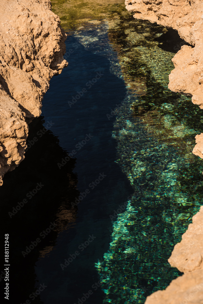 Fototapeta premium A crack in the ground. A rift in the earth full of clean sea water. Result of the earthquake.