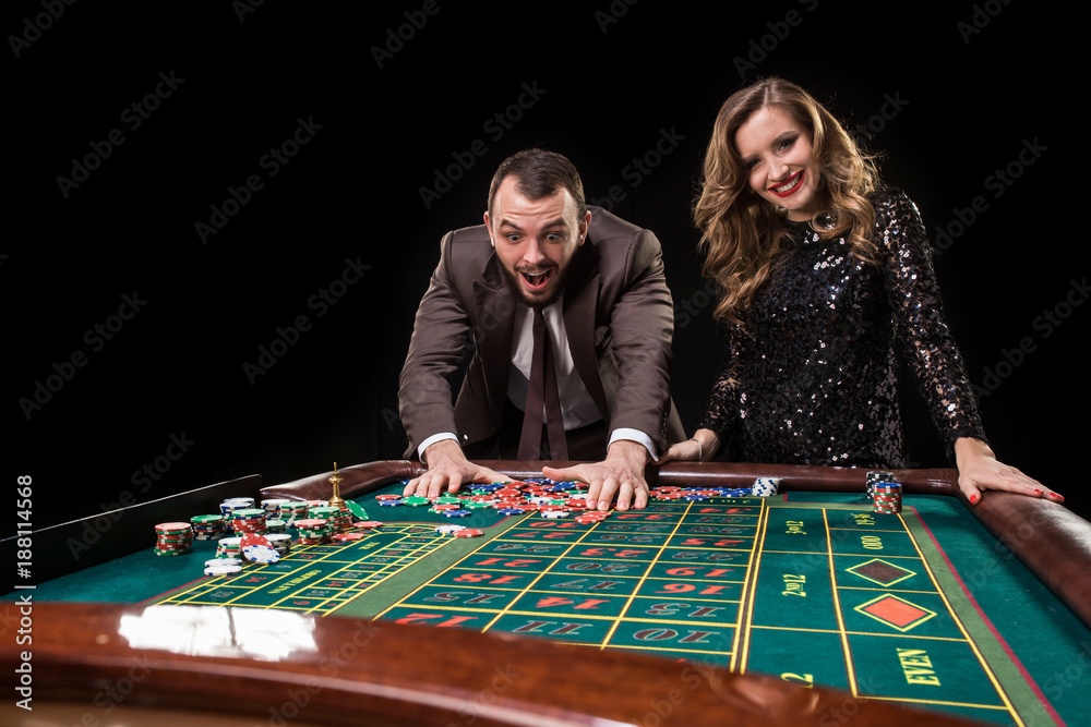 Man and woman playing at roulette table in casino Man and woman playing at roulette table in casino