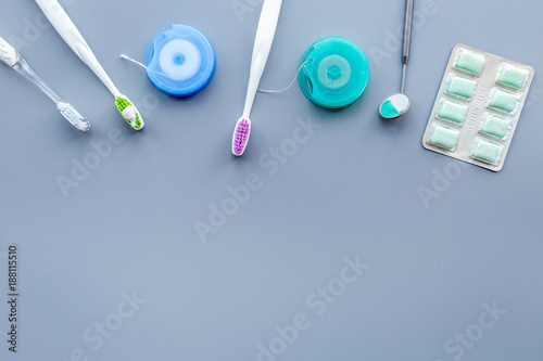 Tools for oral cavity hygiene. Brush, floss, gum, dental mirror on blue background copy space