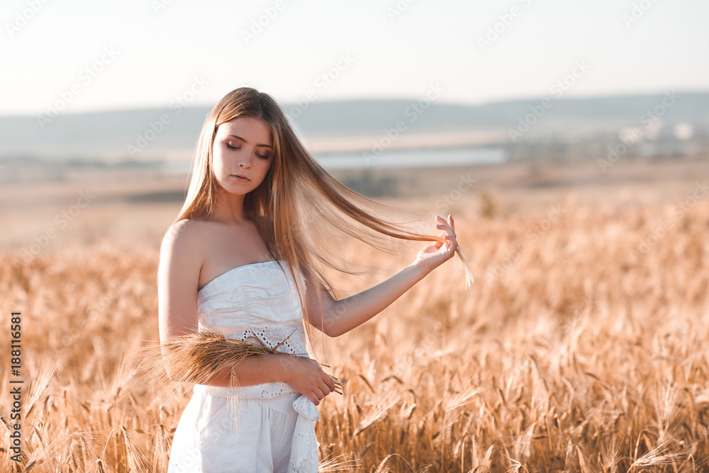 Beautiful blonde teenager girl 14-16 year old holding wheat outdoors. Summer season. 20s. Beautiful blonde teenager girl 14-16 year old holding wheat outdoors. Summer season. 20s.