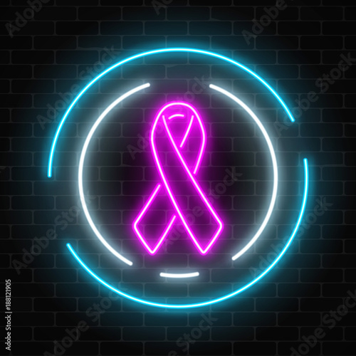 Neon cancer pink ribbon glowing sign on a dark brick wall background. Cancer awareness month symbol.