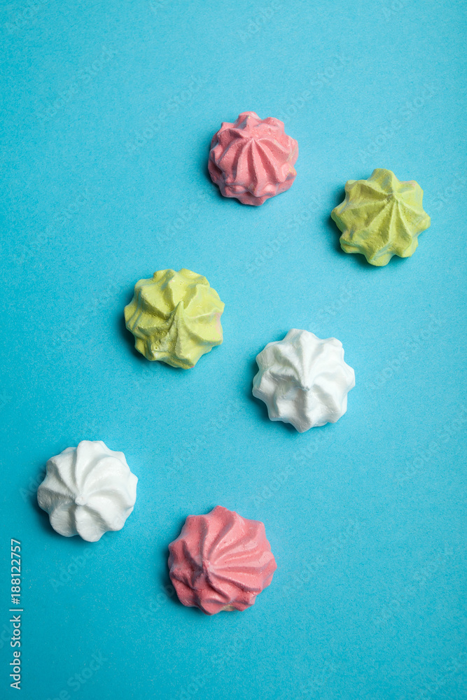 Fototapeta premium Traditional French meringue dessert as a symbol of love and holiday on a blue background.