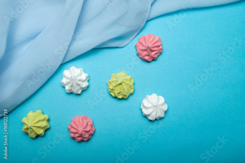 Love gift - air meringues on a blue background. The concept of sweet summer. View from above.