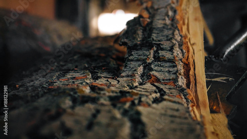 Details of the removal of bark from a log in a sawmill.
