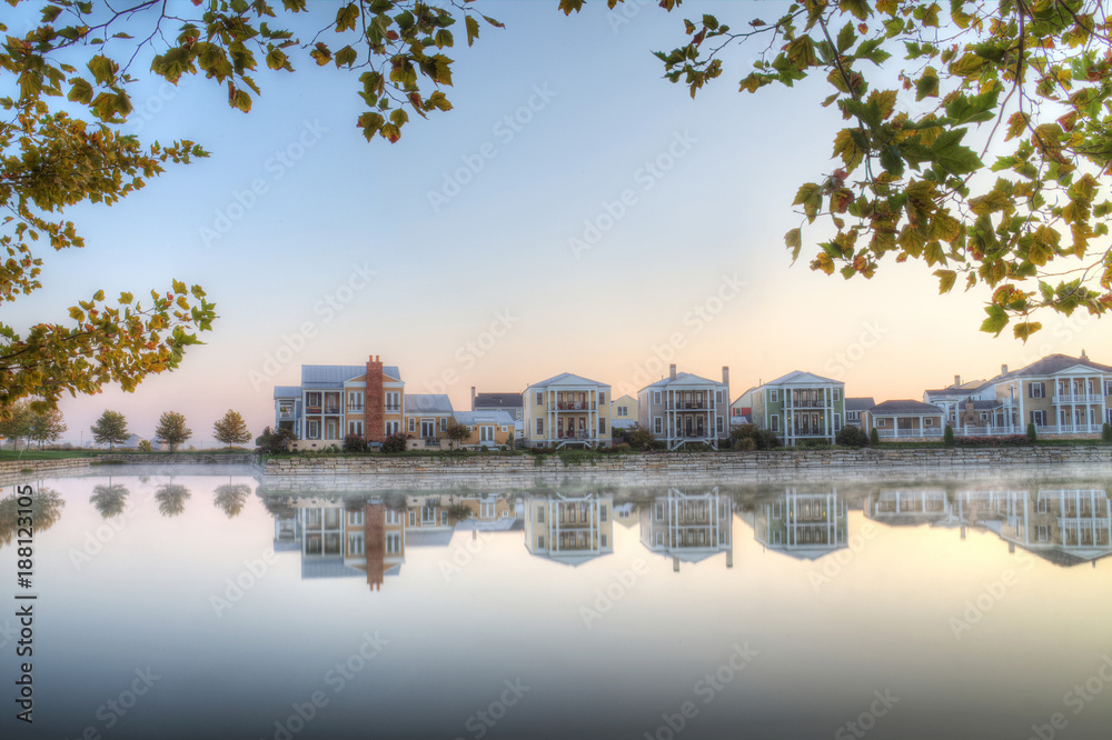 Fototapeta premium suburban neighborhood with lake in foreground with trees