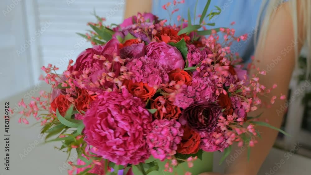 Professional woman floral artist, florist showing beautiful wedding bouquet at workshop, flower shop. Close up shot. Floristry, handmade and small business concept Professional woman floral artist, florist showing beautiful wedding bouquet at workshop, flower shop. Close up shot. Floristry, handmade and small business concept