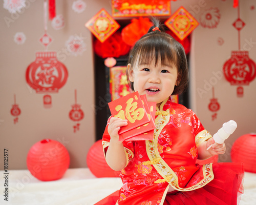 Chinese baby girl  traditional dressing up with a "FU" means "lucky" red envelope