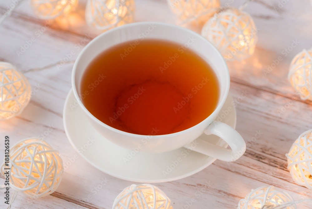 Cup of black tea and Christmas garlands glow Cup of black tea and Christmas garlands glow
