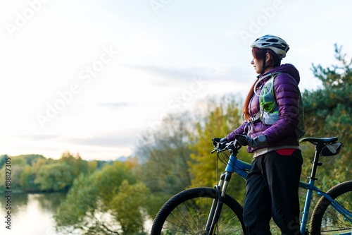 Image of girl with bicycle in helmet in autumn