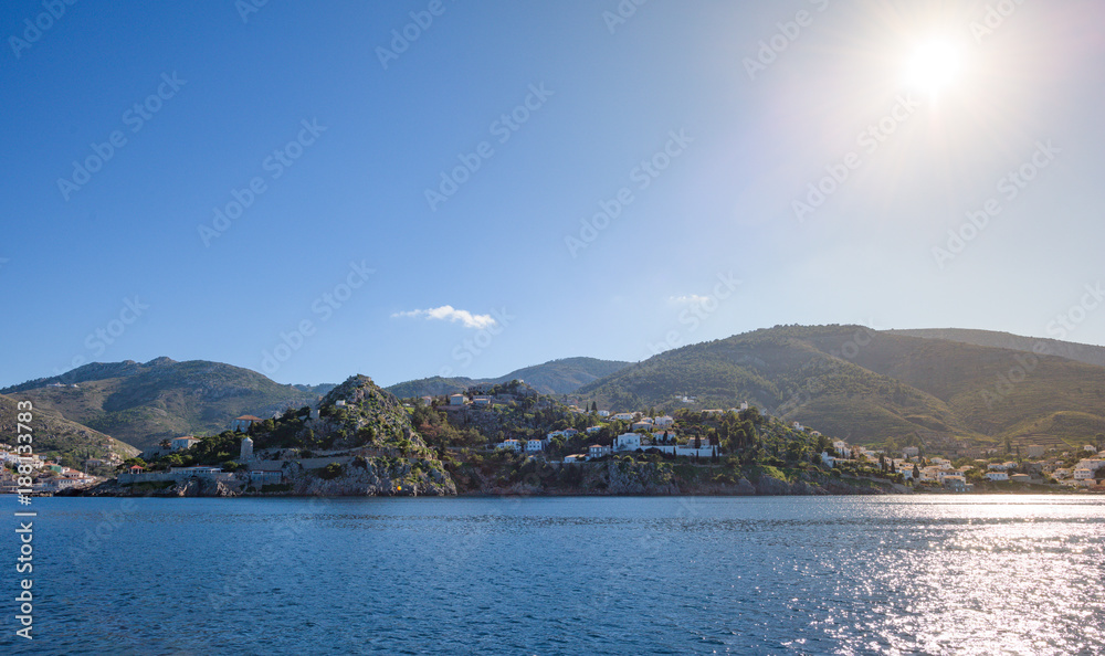 Hydra Island main harbour, seen from the sea, with traditional houses and hills, in Argolid Sea, Greece.