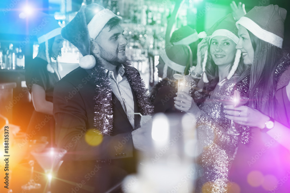 Obraz premium Guy with two girls on new year party in bar