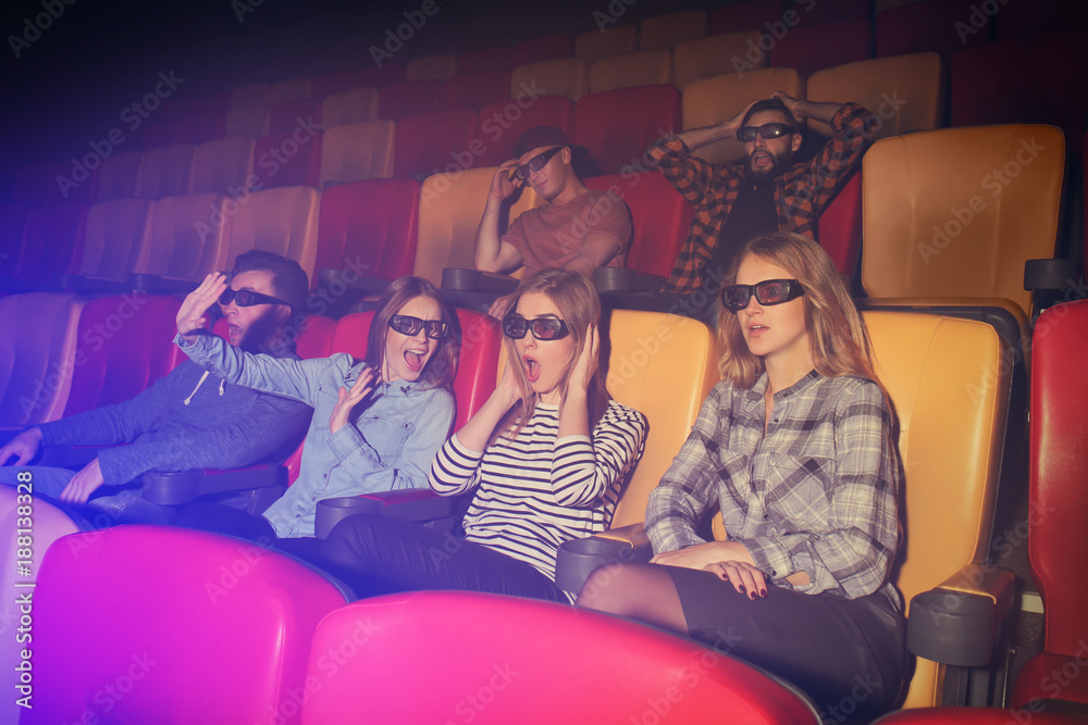 Naklejka premium Young people watching movie in cinema