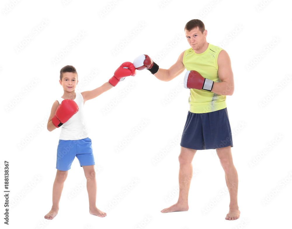 Cute little boy training with boxing coach, on white background