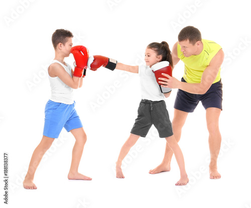 Cute little children training with boxing coach on white background © Africa Studio