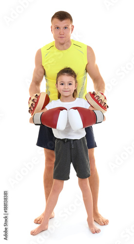 Cute little girl with boxing coach on white background