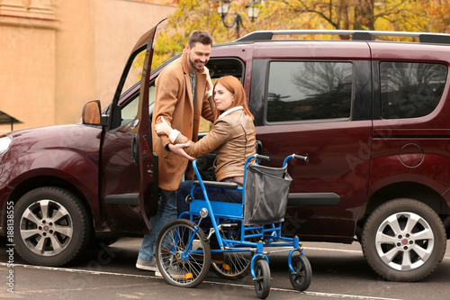 Handsome man and woman in wheelchair near car © Africa Studio