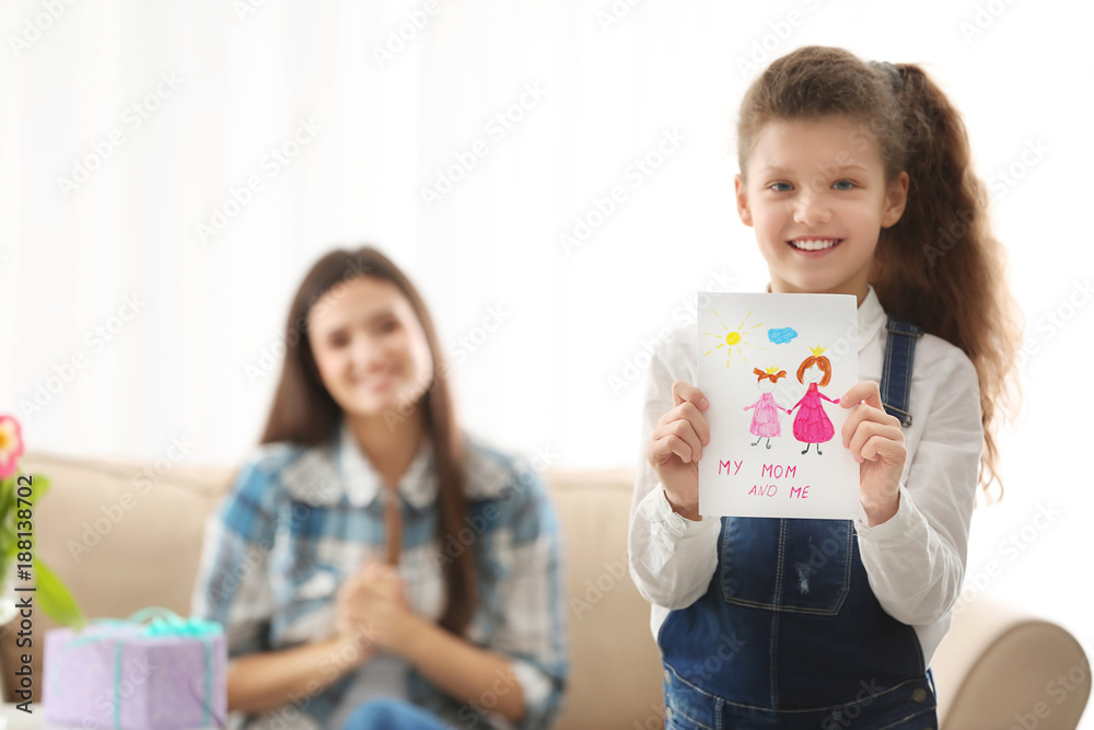 Cute little girl holding greeting card for her mom indoors. Mother's day celebration Cute little girl holding greeting card for her mom indoors. Mother's day celebration