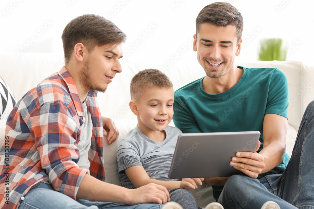 Male gay couple and adopted boy with tablet at home Male gay couple and adopted boy with tablet at home