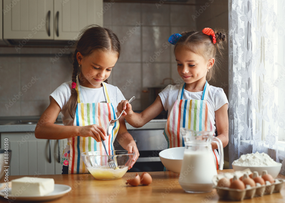 happy sisters children girls bake cookies, knead dough, play with flour and laugh happy sisters children girls bake cookies, knead dough, play with flour and laugh