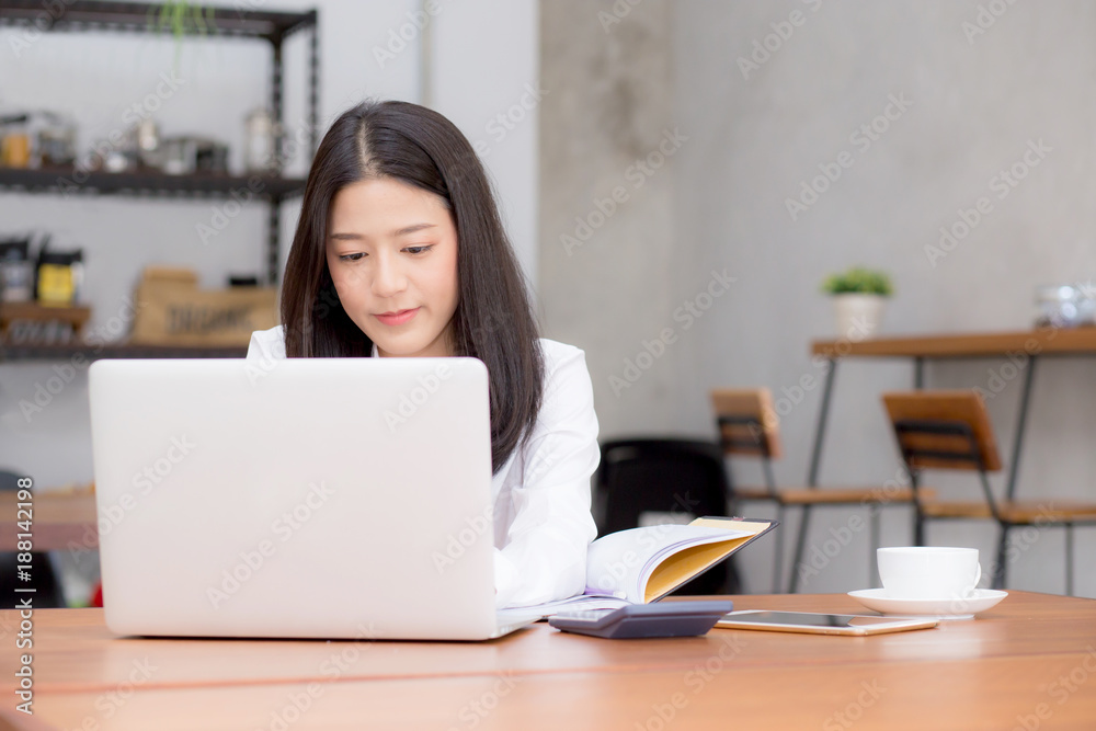 Beautiful asian young woman working online on laptop sitting at coffee shop, professional female freelancer using notebook computer with connect to internet for distance job.