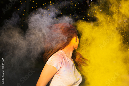 Portrait of brunette woman playing with dry color powder on holi colours festival