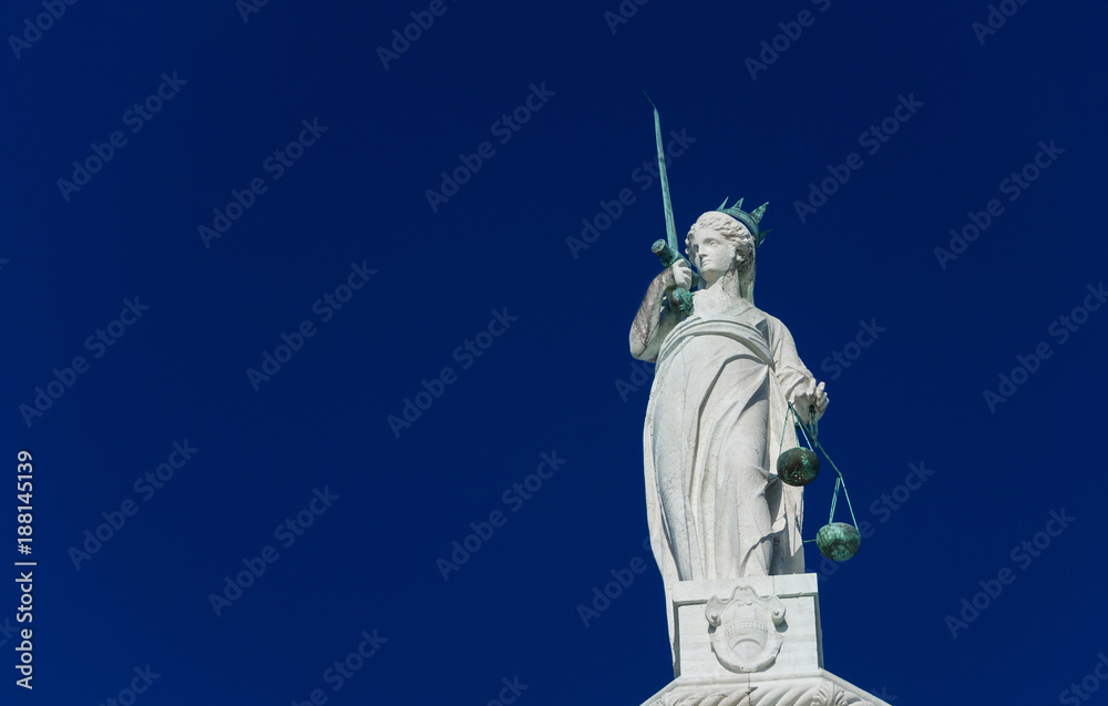 Goddess of Justice statue holding balance scales and sword (with copy space)