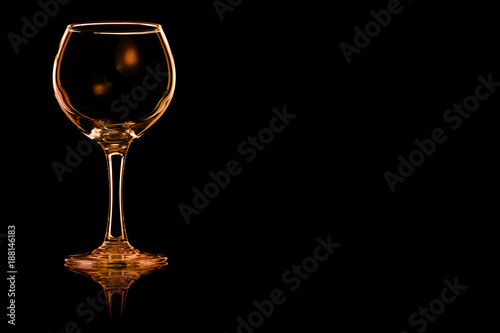 An empty glass of red wine with fire reflection.