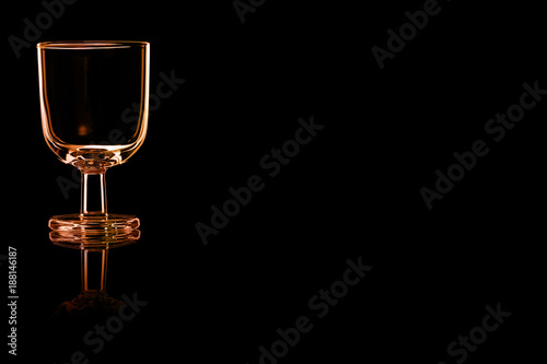 An empty glass of port or sherry with fire reflection.
