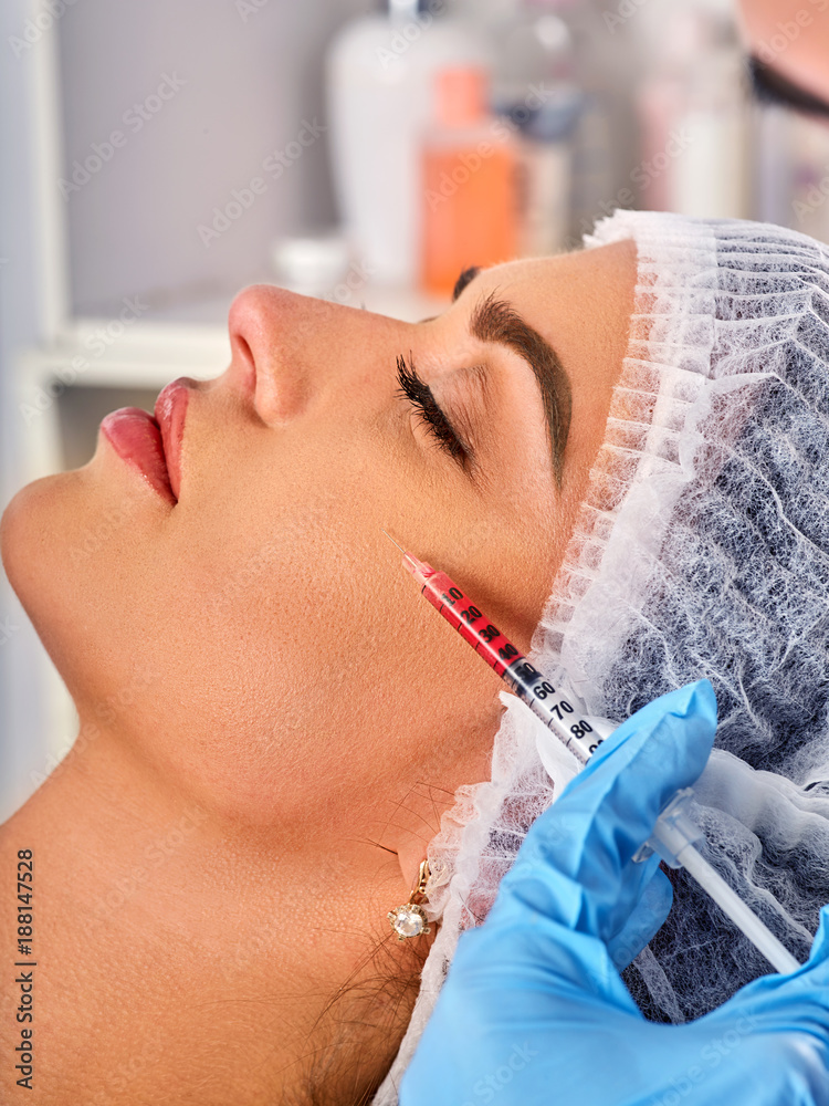 Filler injection for female face. Plastic aesthetic facial surgery and in clinic. Beauty woman giving injections in cosmetology room. Close up of female profile.