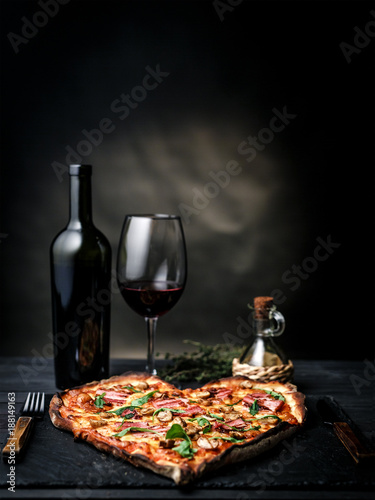Pizza in the shape of heart with wine for St. Valentine's Day