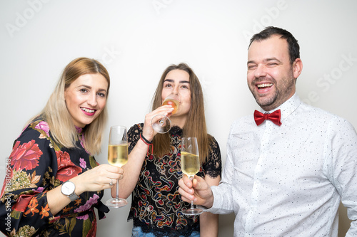 Obraz na płótnie three people funny props pose photo booth happy fun bottle w salonie