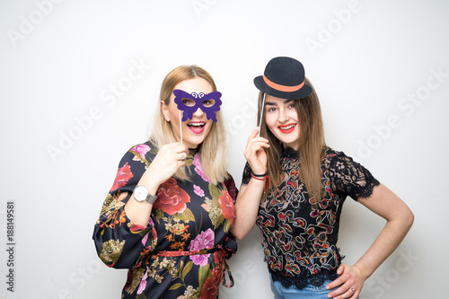 Obraz na płótnie two young girls ladies pose photo booth plain background funny props w salonie