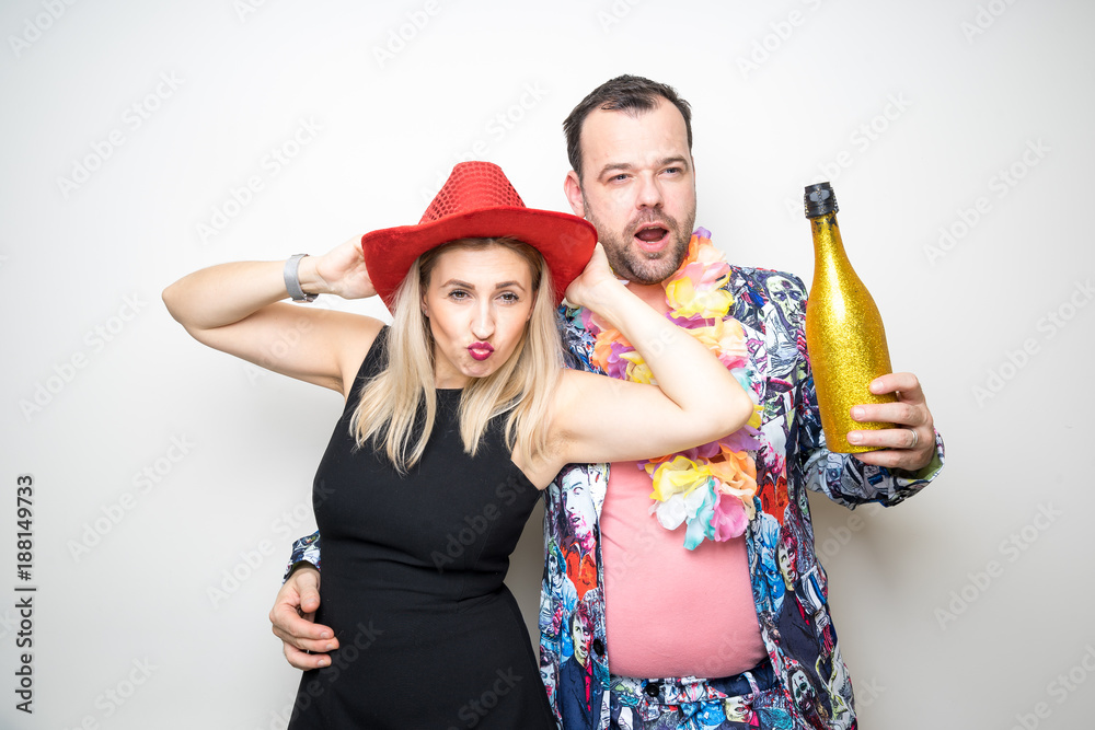 young couple funny props pose photo booth plain background