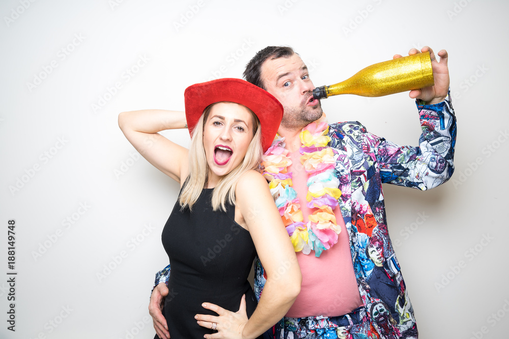 young couple funny props pose photo booth plain background