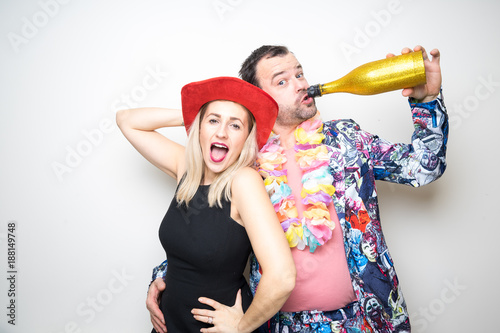 Obraz na płótnie young couple funny props pose photo booth plain background w salonie