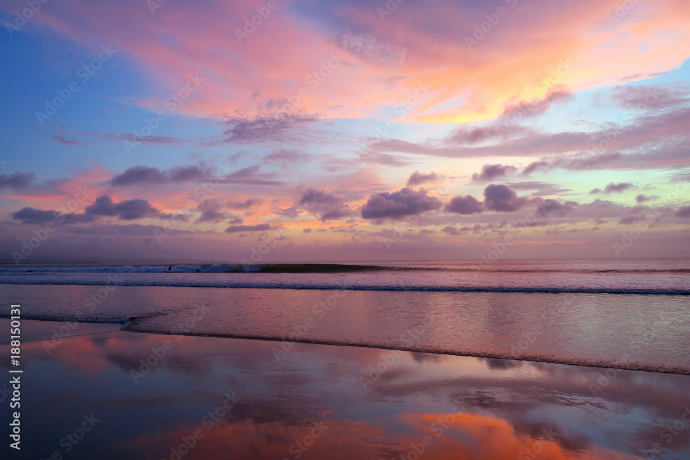 Violet sky and mirror reflection sunset at Kuta beach, Bali, Indonesia