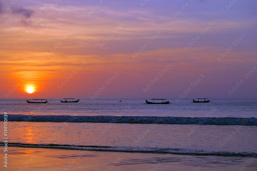 Beautiful red sun sunset with fisherman's boats silhouettes, Kuta beach, Bali Beautiful red sun sunset with fisherman's boats silhouettes, Kuta beach, Bali