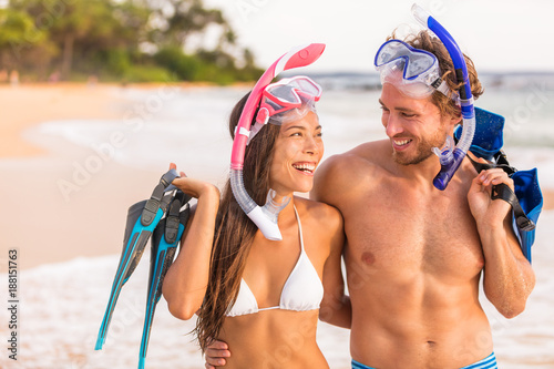 Happy couple laughing together beach fun on summer snorkel travel vacation healthy active lifestyle. Sports leisure young friends doing snorkelling swim activity at Hawaii tropical holidays.
