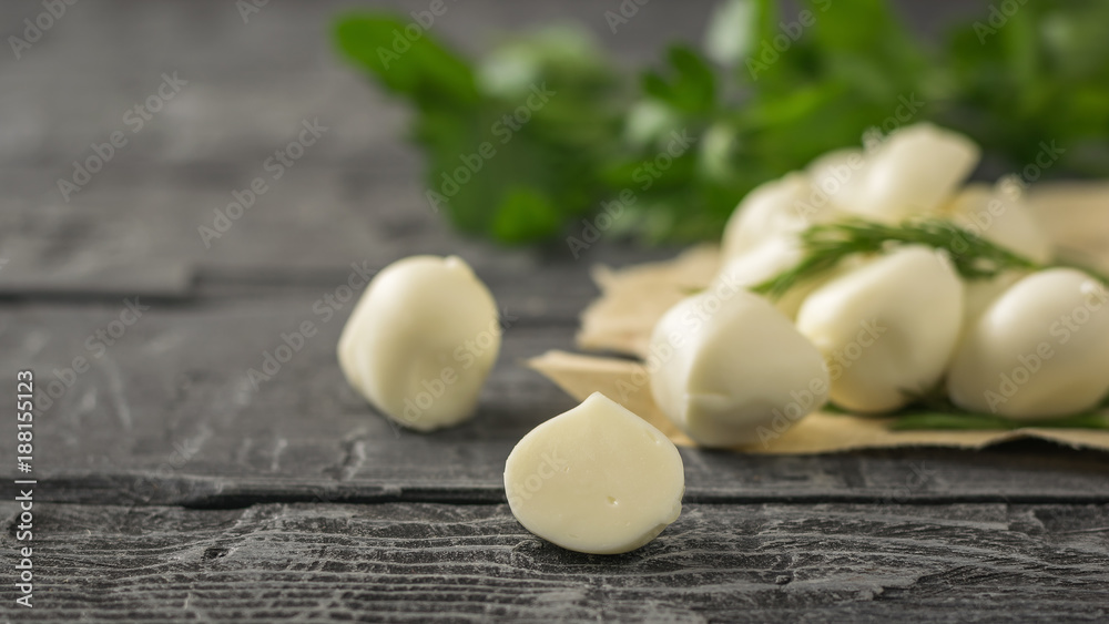Freshly made mozzarella cheese with parsley on a wooden table. Selective focus. Freshly made mozzarella cheese with parsley on a wooden table. Selective focus.