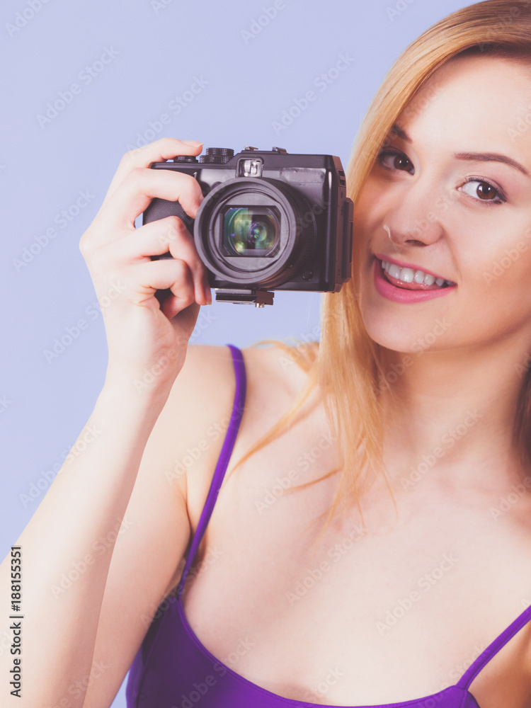 Blonde woman with camera on blue Blonde woman with camera on blue