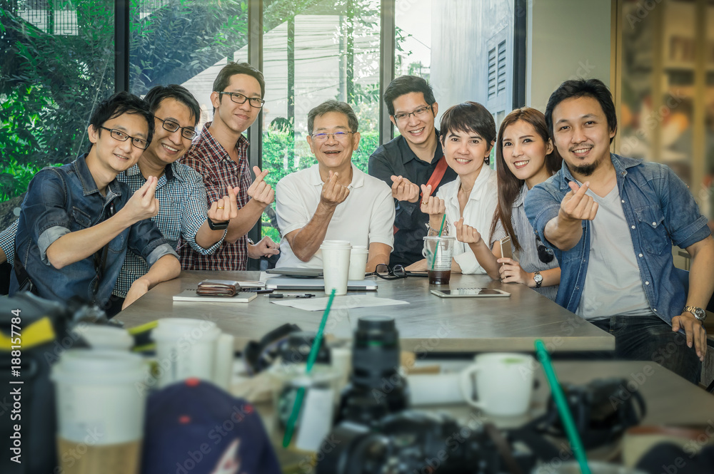 Obraz premium Group Of Asian Business people with casual suit doing small heart with happy action and celebrate in the Office or coffee shop, people business group concept