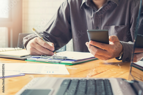 Business and finance concept of office working, Businessmen using smart phone to discussing analysis Chart