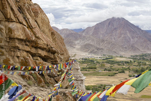 Himalayan mountains and colorful Buddhist prayer flags on the stupa near Buddhist monastery in Ladakh, India