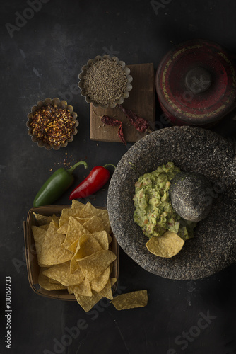 Overhead view of tortilla chip and guacamole in mortar and pestle