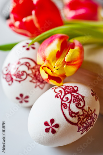 Traditional Czech easter decoration - white eggs with floral red pattern in the nest cupcakes. Spring easter holiday arrangement.